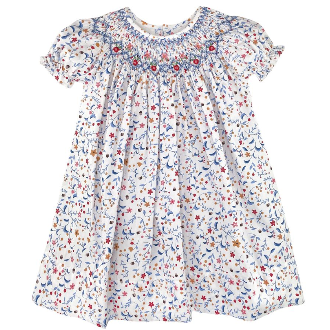 short sleeve bishop with floral print in blues and reds and  golds with blue smocking and red rosettes