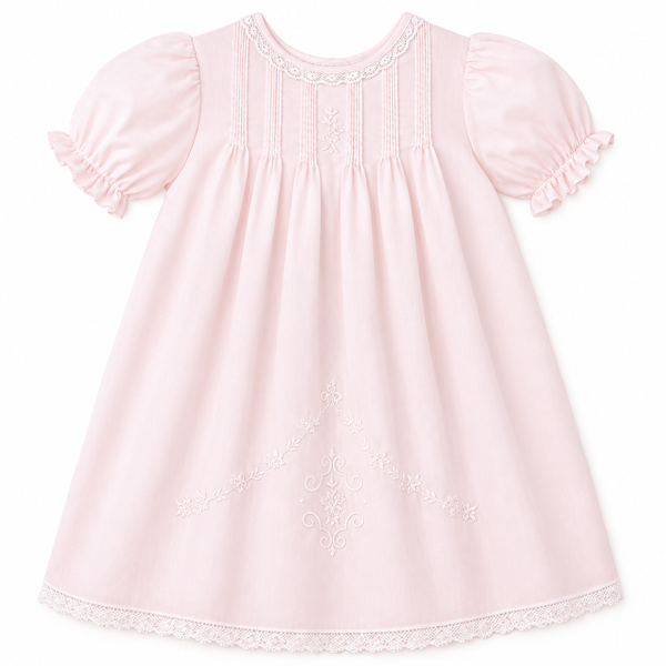 Pink baby dress with pintuck pleats, puff sleeves, lace trim, embroidery details, and matching slip underneath.