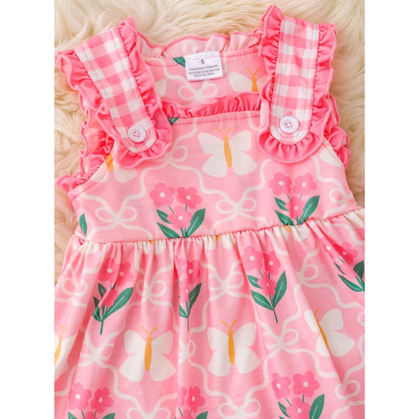 Pink children's dress with floral and butterfly pattern on a white background