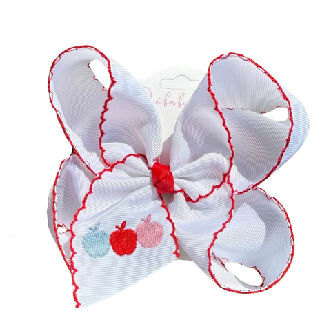 White grosgrain hair bow with red scalloped edges and embroidered apple trio in blue, red, and pink on the tail