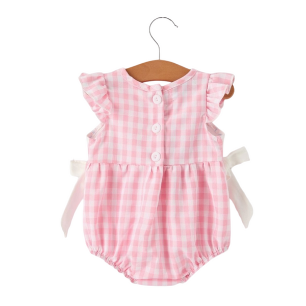 Back view of the pink gingham romper with ruffle sleeves, three white buttons down the back, and tied white side bows.