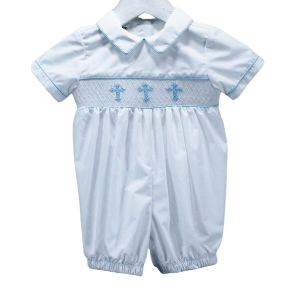 Traditional style boy romper in solid white piped at the sleeves, collar and bodice in light blue with light blue crosses smocked at the bodice.