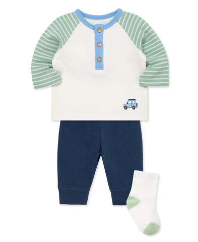 cream shirt with green stripped sleeve and a car on the front. has matching navy pants and matching green and white socks
