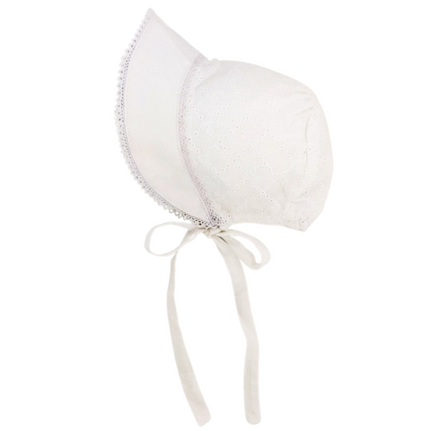 White baby bonnet with bow eyelet embroidery, scalloped brim trim, and chin ties, displayed on flat surface.