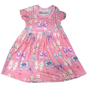 Pink short-sleeve dress with colorful all-over bow print in various patterns, featuring a gathered waist and full skirt.