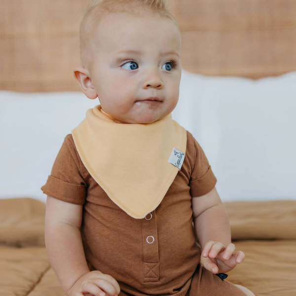 Baby boy wearing a peach Copper Pearl bandana bib