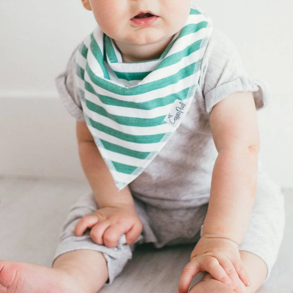 Baby wearing a green and white striped bandana bib 