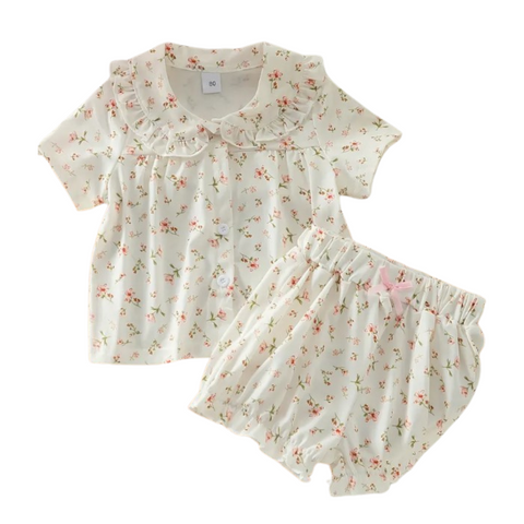 white with pink floral short sleeve and short set. has a rounded collar with ruffles. 