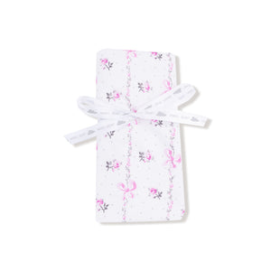 Baby blanket with soft pink interior and floral bow-printed exterior, finished with matching pink ruffle trim