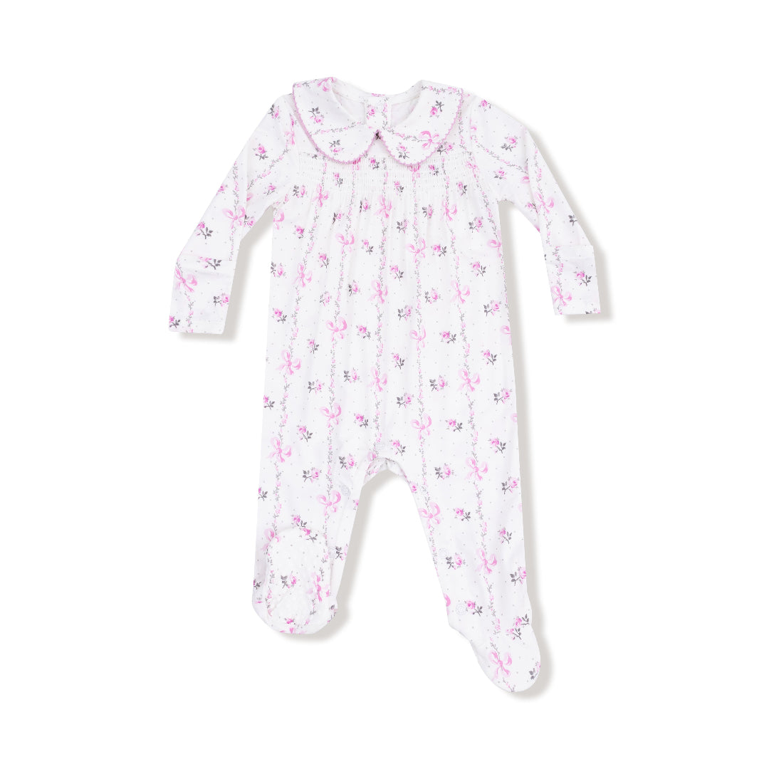 Front view of a long-sleeve baby footie with pink bow stripe print, smocked chest, and Peter Pan collar with pink trim