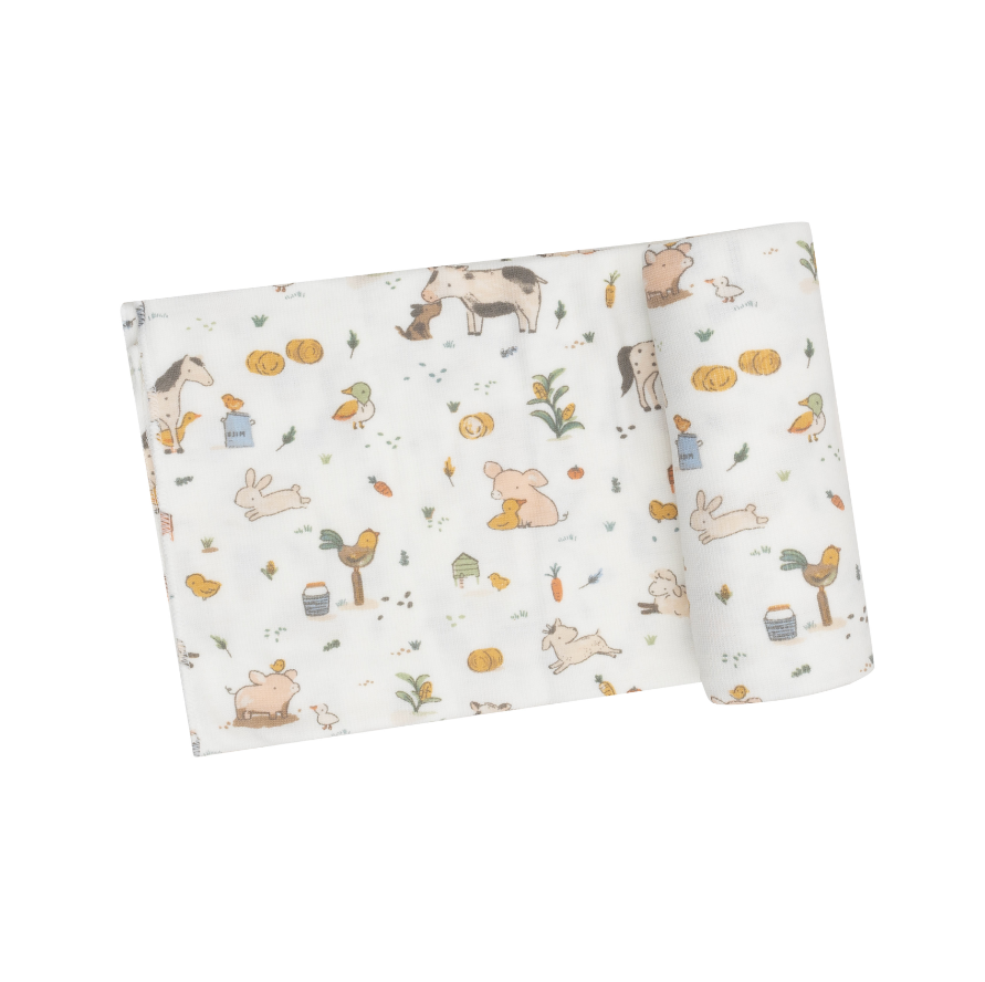 white swaddle blanket with farm animals like horses, chickens, roosters, and pigs