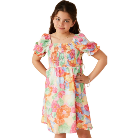 Girl wearing a colorful smocked dress with puff sleeves and a square neckline, featuring a bold floral watercolor print.
