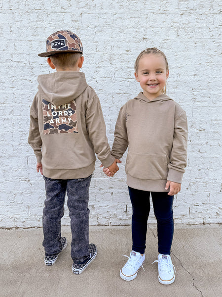 A girl and boy modeling a tan hoodie with camo and the text of "In the Lord's Army."