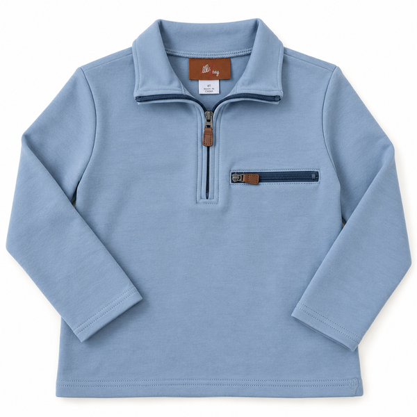 A light blue long-sleeve quarter-zip pullover sweater with a mock neck collar, featuring a zippered chest pocket with a brown leather accent tab, shown on a plain white background.