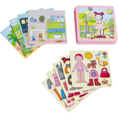 Magnetic Lilli dress-up set with outfit pieces, accessories, and illustrated scene boards in a pink storage tin.