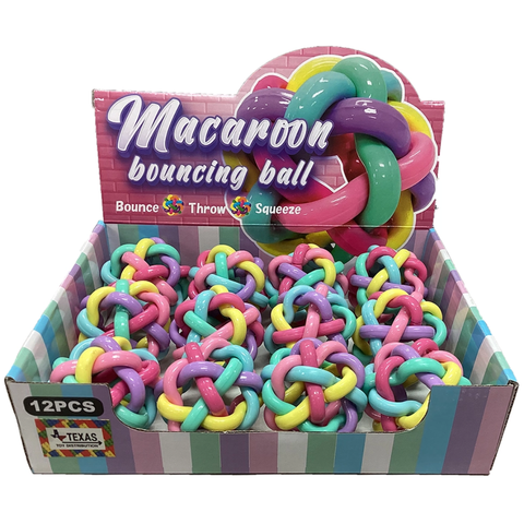 Display box of pastel macaroon-style bouncing balls in pink, teal, yellow, and purple.