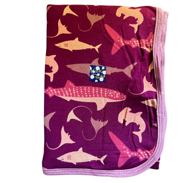 bamboo swaddling blanket with a dark fuchsia background and coordinating colors of sea life  and sharks 