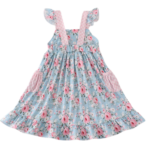Back of girl's blue rose print dress showing elastic waistband, ruffled hem, and pink gingham straps.