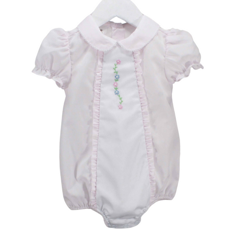 light pink baby girl bubble with a Pink baby bubble with a white center insert, pink ruffles along the sides, a delicate picot stitch on the collar, and puff sleeves. The center bodice features a hand-embroidered floral accent.