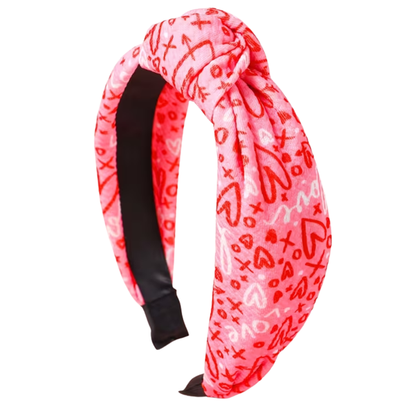 Pink headband with black interior and red heart patterns on a white background