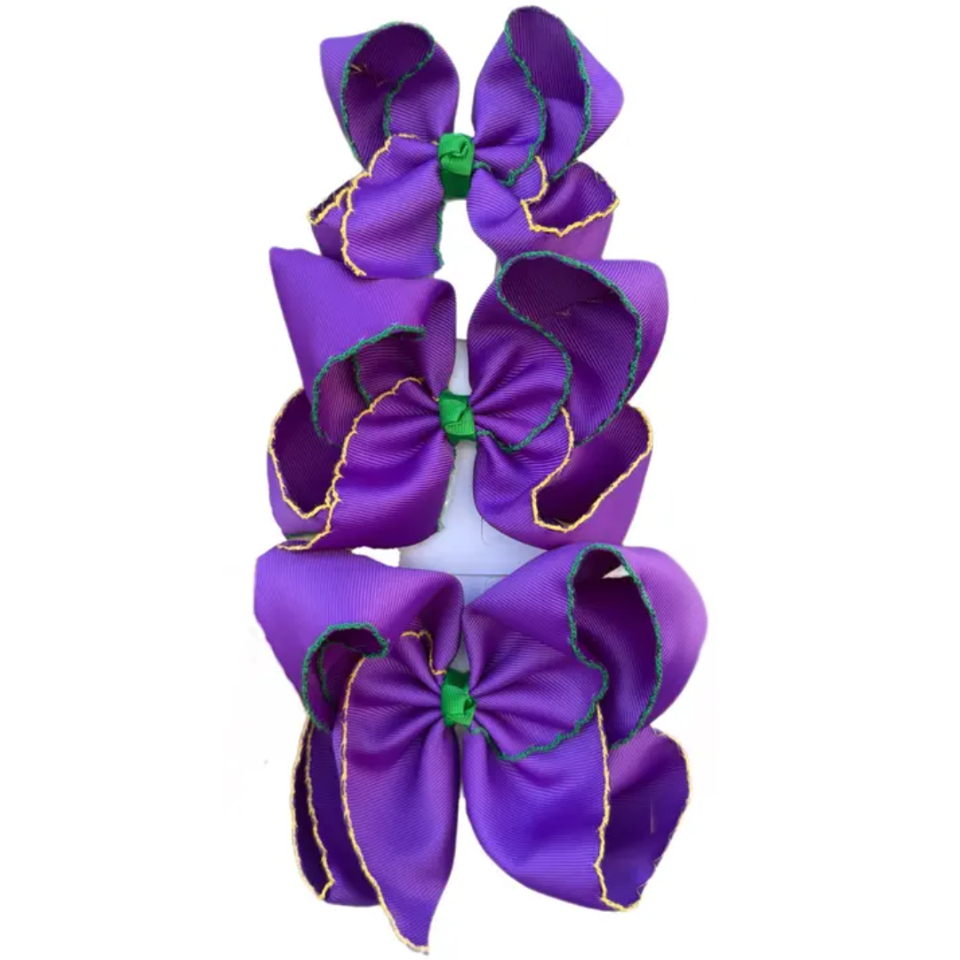 Purple grosgrain hair bows with green and gold moonstitch trim, shown in multiple sizes stacked vertically.