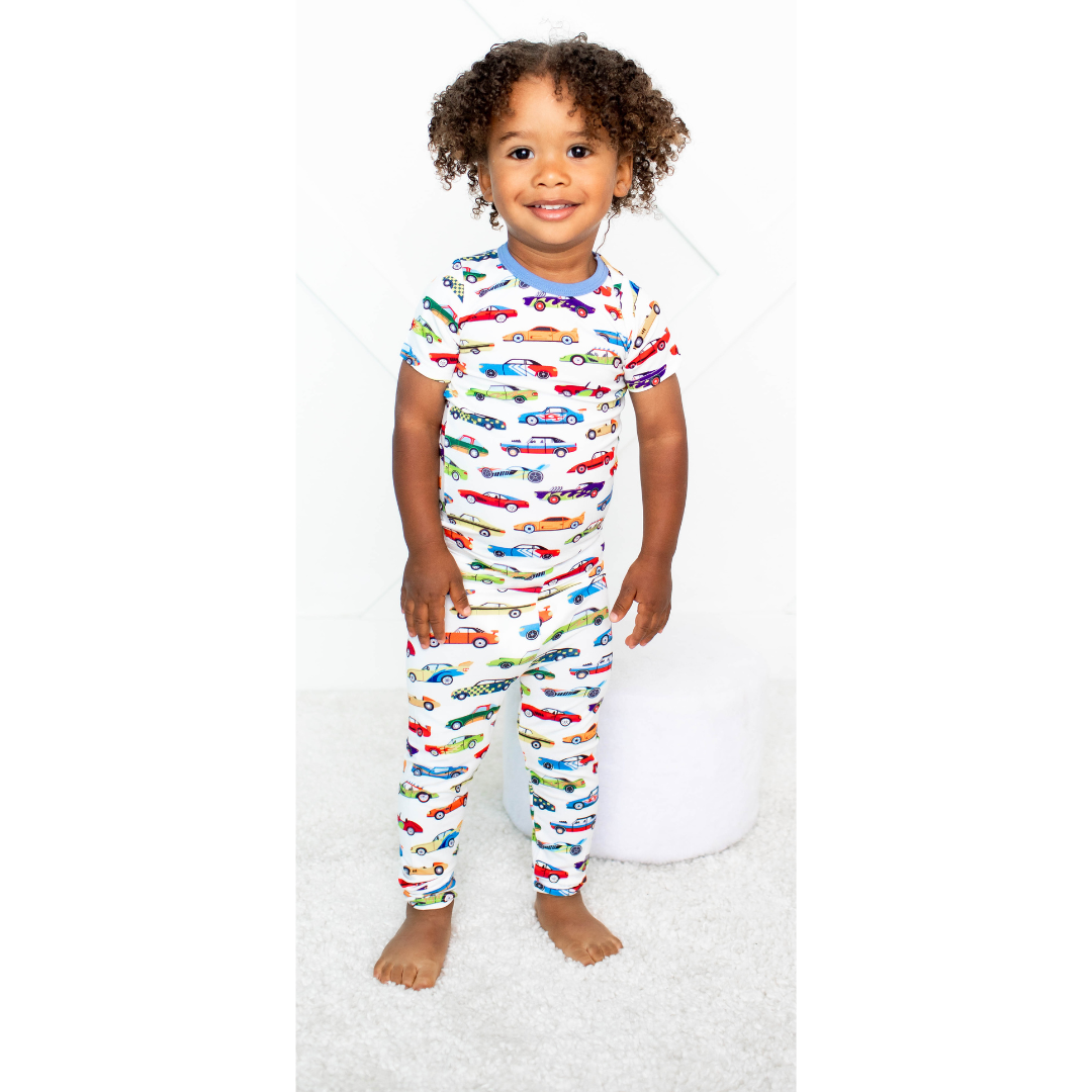 Kids' pajama set with a colorful racing car print, featuring a long-sleeve top and matching pants.