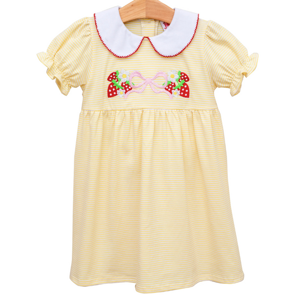 yellow dress with a white collar and red trim. has strawberries, daisies, and a pink bow on the front. 