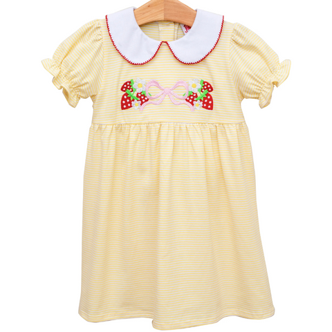 yellow dress with a white collar and red trim. has strawberries, daisies, and a pink bow on the front. 