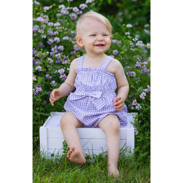 live photo of a little girl wearing the purple gingham romper