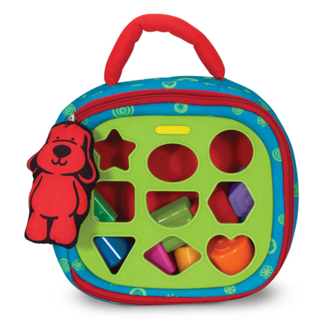 Soft take-along shape sorter bag with green shape panel, colorful pieces, handle, and attached red puppy plush.