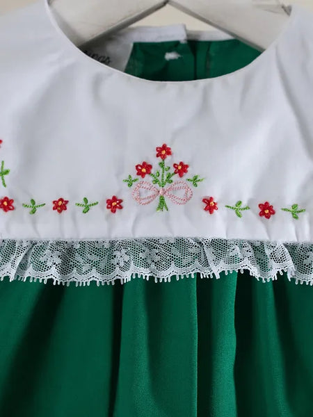 close up picture of white bid collar with red and green flower designs