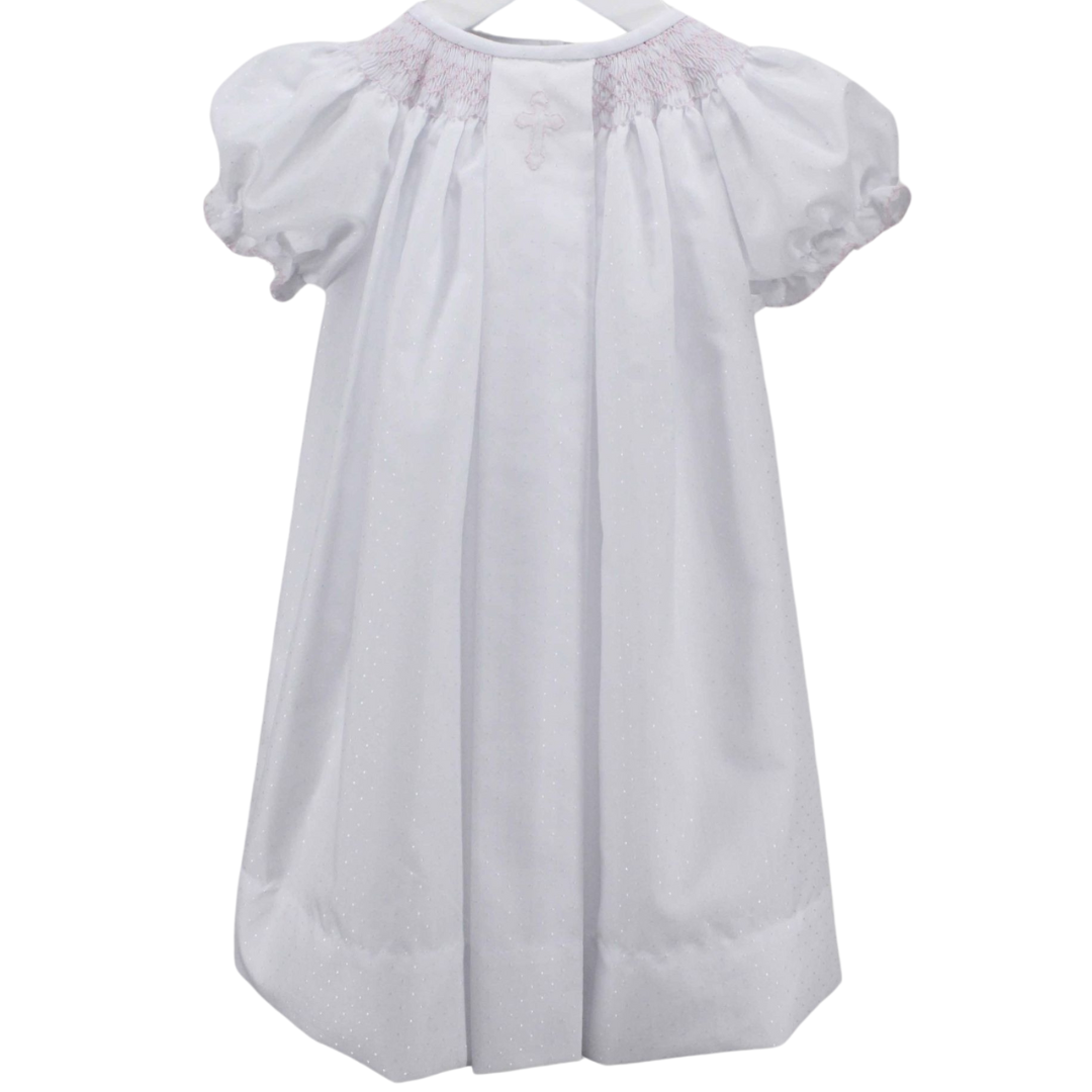 long white dress with pink smocked neckline and pink cross