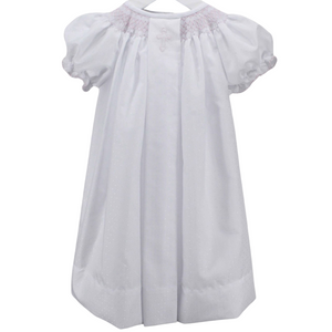 long white dress with pink smocked neckline and pink cross