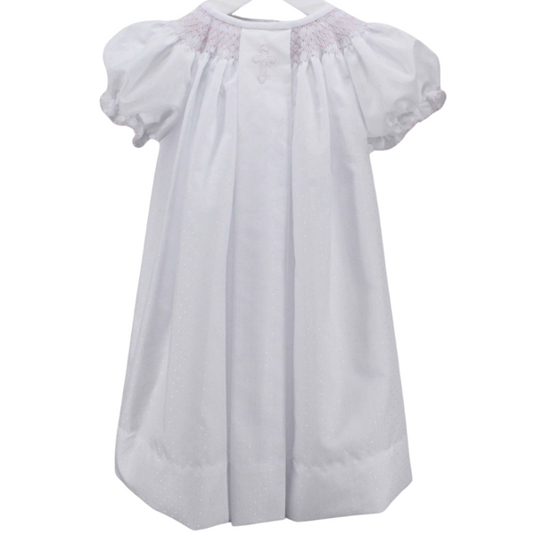 long white dress with pink smocked neckline and pink cross