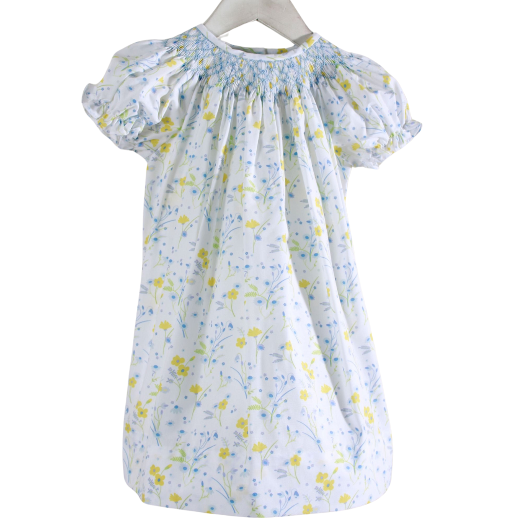 white dress with yellow and blue flowers and blue smocked neckline
