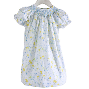 white dress with yellow and blue flowers and blue smocked neckline
