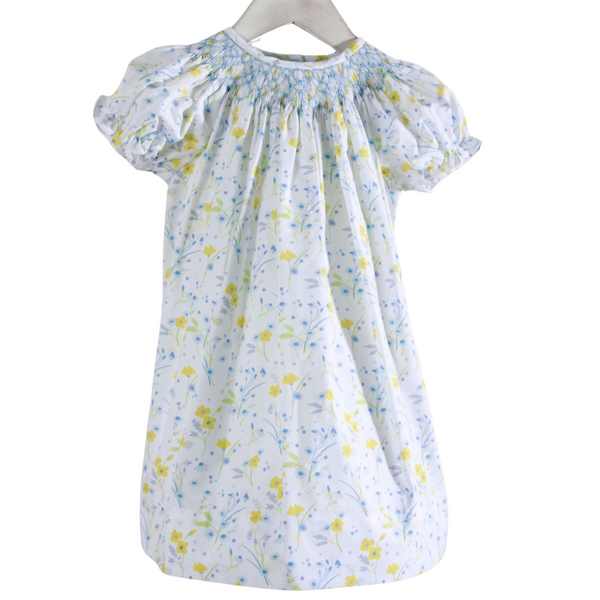 white dress with yellow and blue flowers and blue smocked neckline

