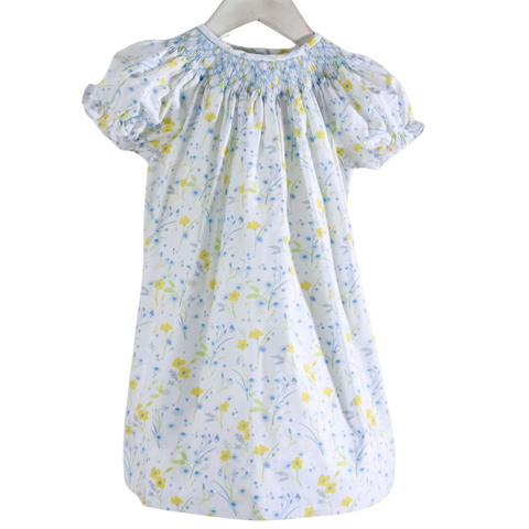white dress with yellow and blue flowers and blue smocked neckline

